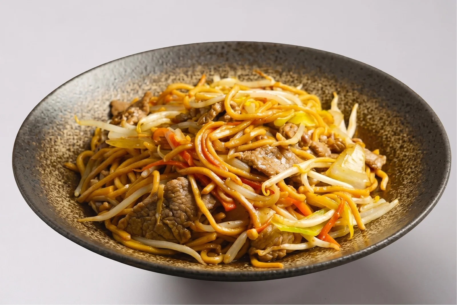 Plate of stir-fried beef noodles with cabbage, carrots and bean sprouts